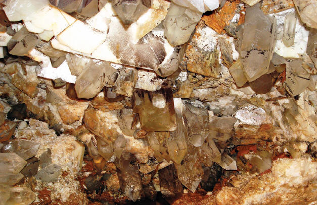 Huge quartz, feldspar, mica and topaz crystals (at the center) in the pocket. Saw Naung U photo.