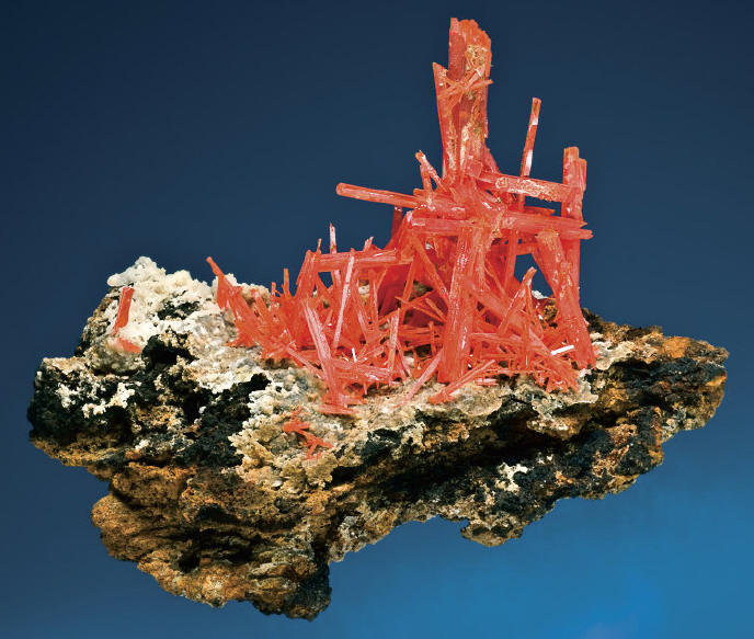 Group of red-orange crystals of crocoite on matrix, 9.6 cm wide. Gobin specimen. J. Scovil photo.