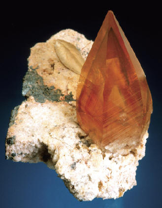 Calcite crystal on matrix, 3.3 cm high. P. Lyckberg specimen. J. Scovil photo.